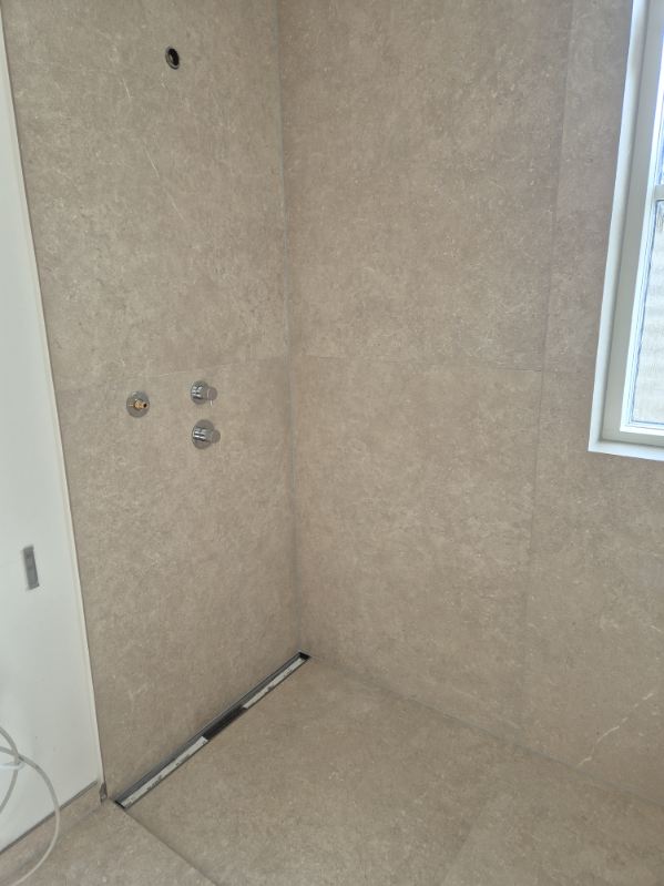 Walk-in bruser med storformatfliser og indbygget armatur